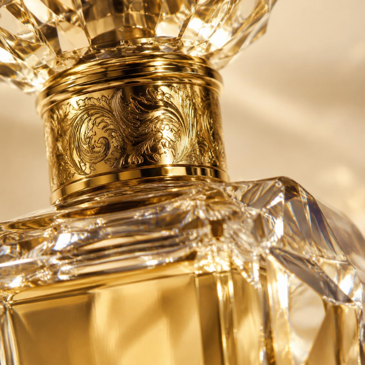 Detalle del cuello grabado en oro de un frasco de cristal